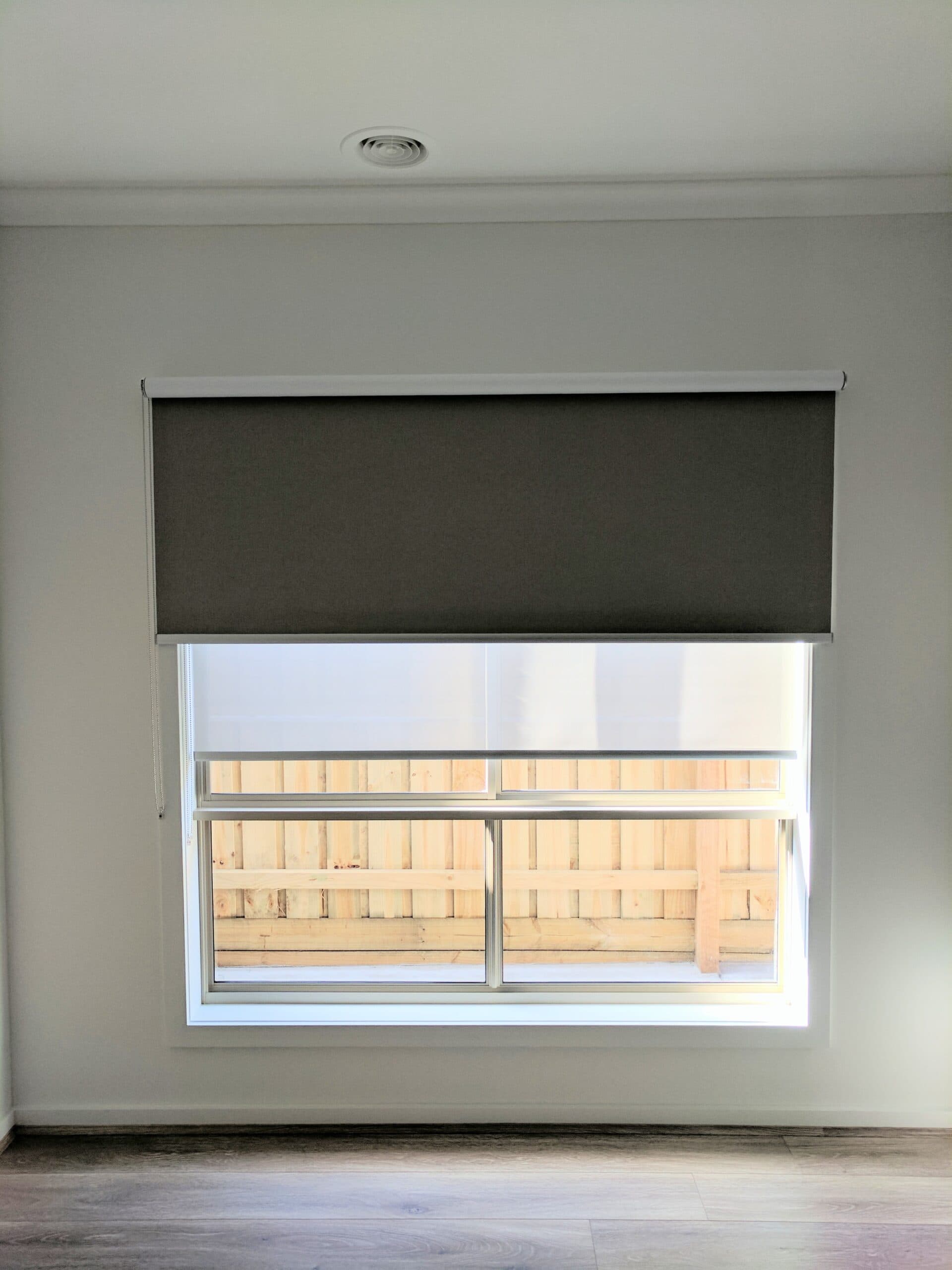 Charcoal blockout roller blind on a bedroom window
