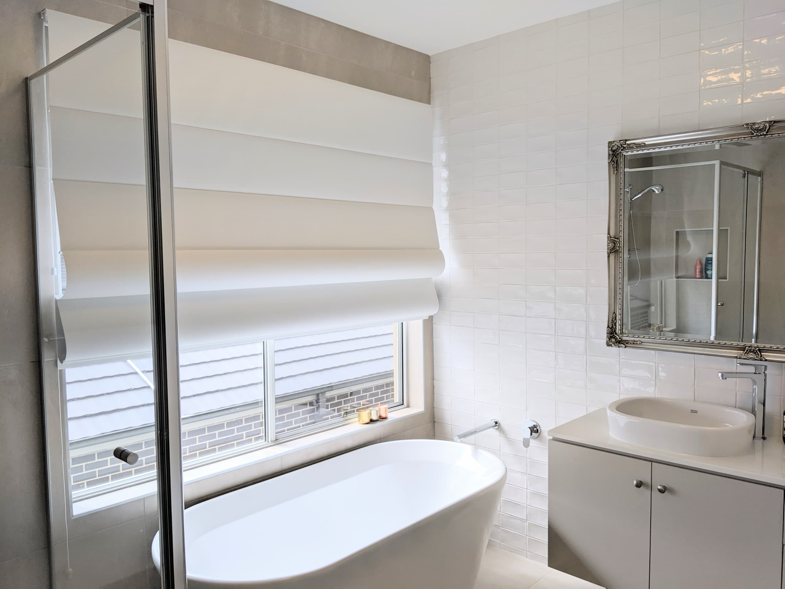 White roman blind above a freestanding bath