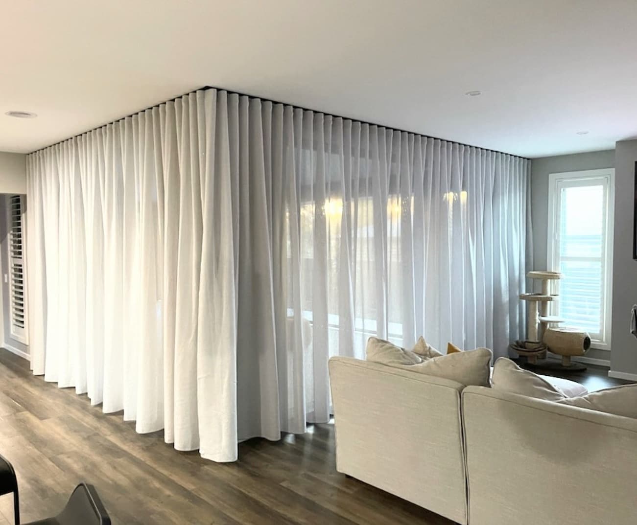 Sheer curtains on a ceiling-fixed track running around a corner