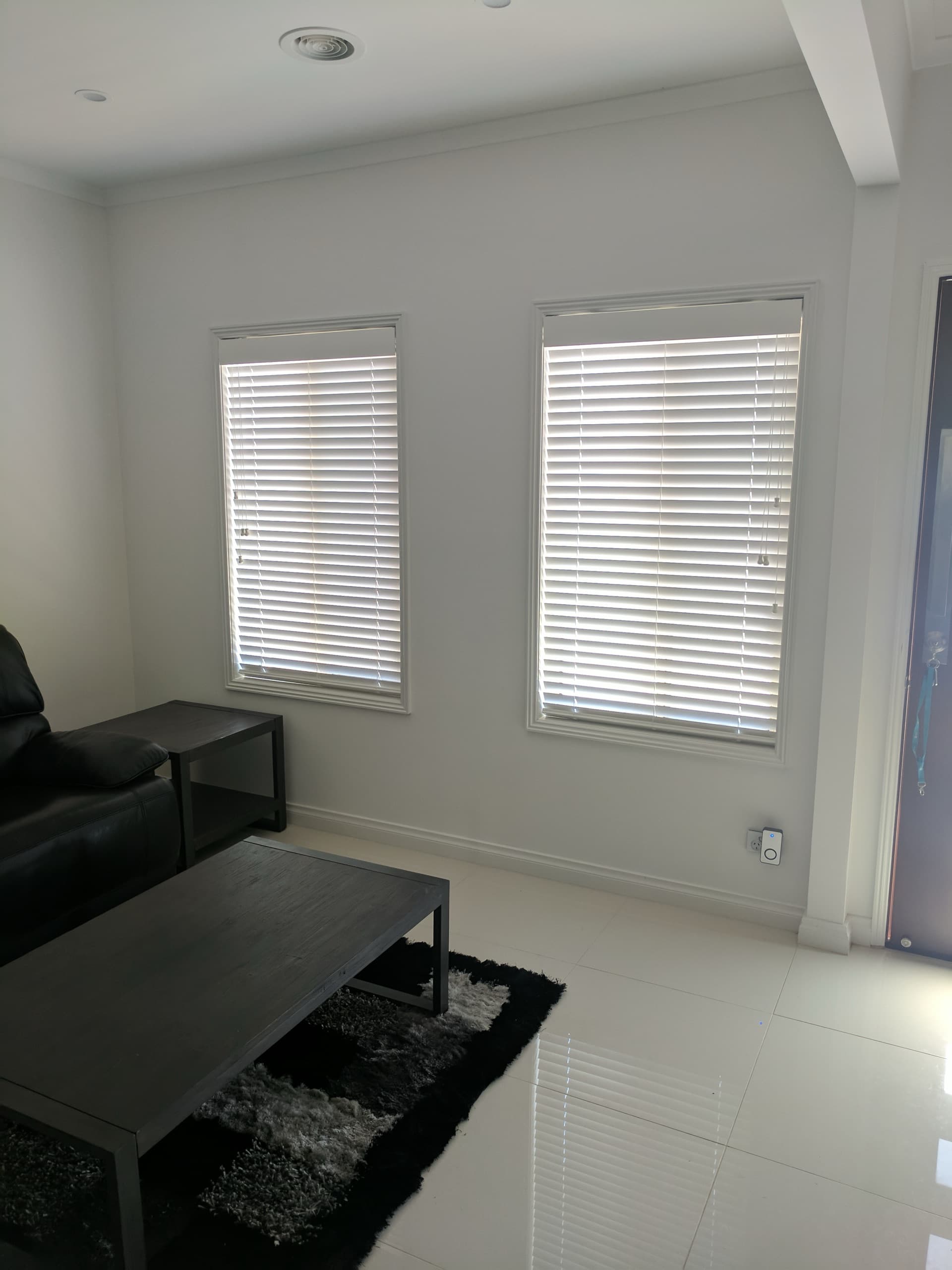 White venetian blinds on two living room windows