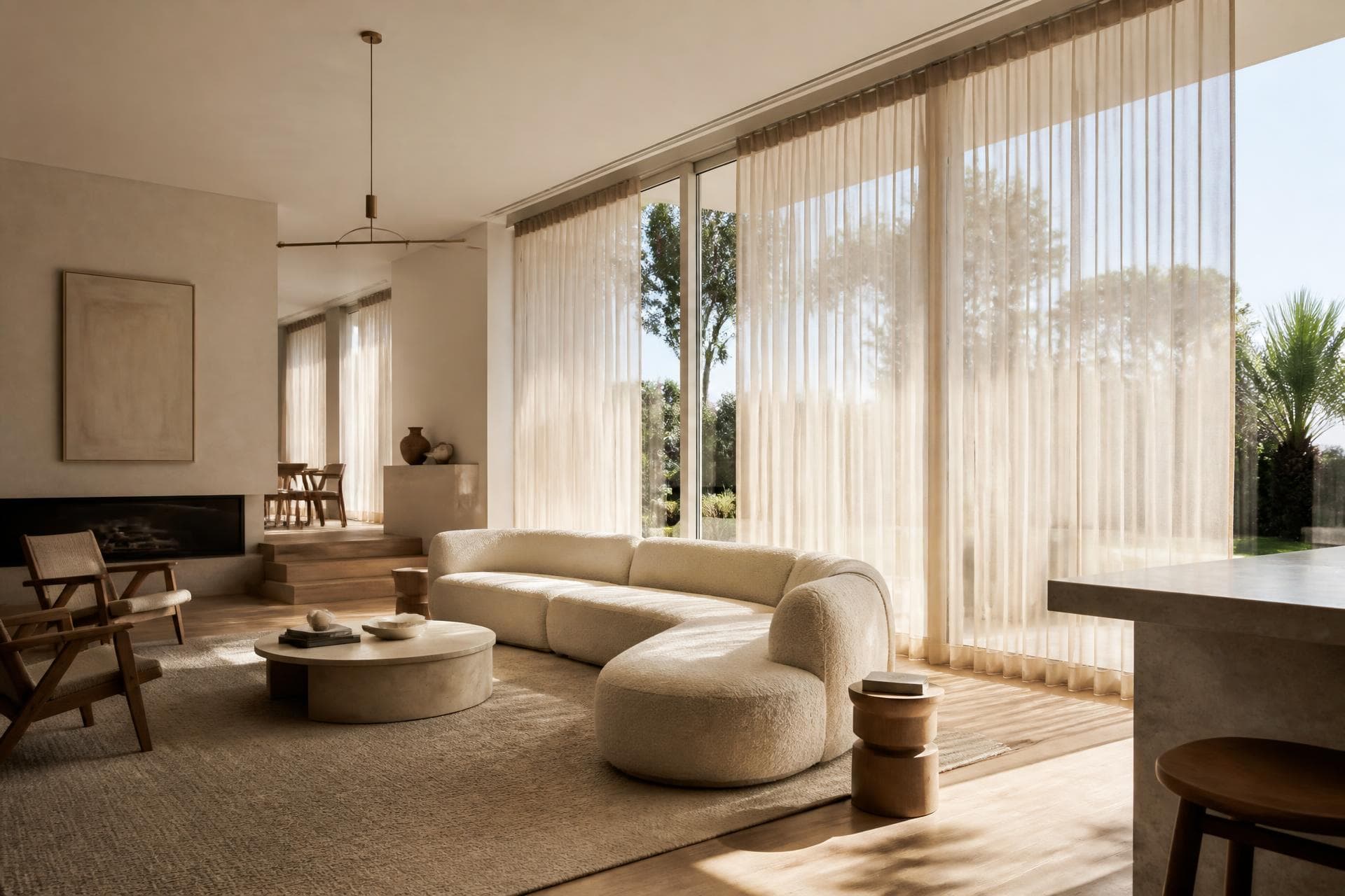 Sheer curtains on floor to ceiling windows in a light-filled living room